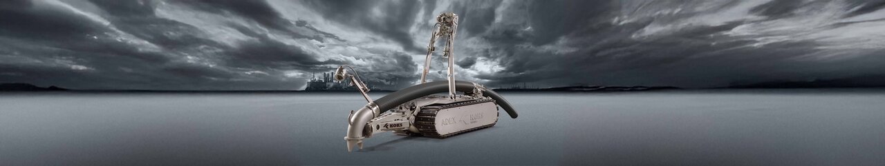 Roboter mit Schlauch, der Richtung Boden zeigt, und Kameras, zur Steuerung durch einen Mitarbeiter. Im Hintergrund ist weit in der Ferne Industrie-Landschaft zu sehen, zusammen mit dunkelgrauen Wolken und Boden.